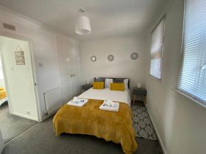 ein Schlafzimmer mit einem Bett mit zwei Handtüchern darauf in der Unterkunft Marie’s 3 bedrooms Shakespeare house in Bedford