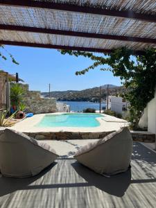 a view of a swimming pool with two chairs under a pergola at Venereum Apartments in Faros