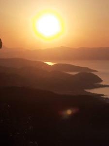 a sunset over a body of water with the sun at Maria's in Mirsíni