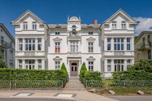 a large white house with a staircase in front of it at Villa Elisabeth Wohnung Welle in Heringsdorf