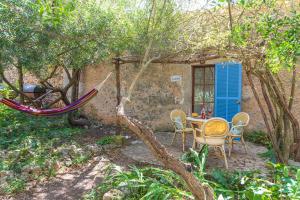 una hamaca en un jardín con mesa y sillas en Sa Casa Rotja en Sineu