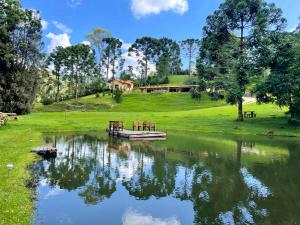 een boot op een rivier met een huis op de achtergrond bij Linda Casa de campo c lazer prox Camp do Jordao SP in Campos do Jordão