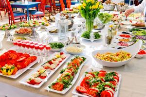 una mesa larga con muchos platos de comida. en Domek przy promenadzie, en Kołobrzeg