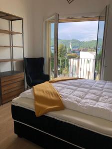 sypialnia z łóżkiem, krzesłem i oknem w obiekcie Ferienwohnung Laveno w mieście Laveno