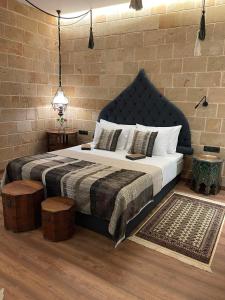 een slaapkamer met een groot bed en een bakstenen muur bij Utopia Luxury Suites - Old Town in Rhodos-stad