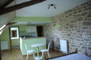 a kitchen and a living room with a stone wall at Gîtes de Lez in Laguépie