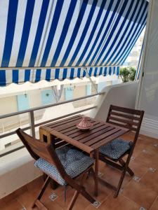 drewniany stół i 2 krzesła na balkonie z dachem w obiekcie La Costilla centro y playa w mieście Rota