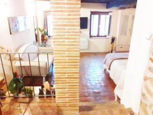 un soggiorno con letto e muro di mattoni di Il Bugigattolo a Castagneto Carducci
