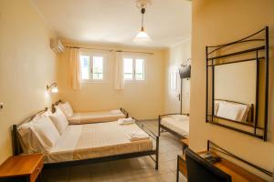 Habitación pequeña con cama y espejo. en Phevos Villa en Perissa
