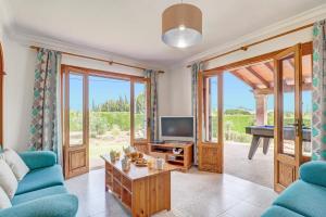 a living room with a tv and a couch and a table at Villa Bauza by Villa Plus in El Port