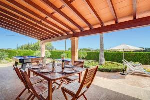 a wooden table with chairs and a ping pong ball on a patio at Villa Bauza by Villa Plus in El Port