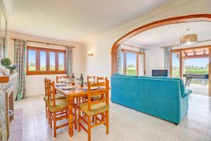 a living room with a table and a blue couch at Villa Bauza by Villa Plus in El Port