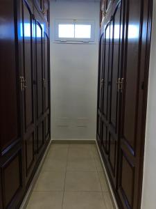 a hallway with wooden doors and a window at Duque Nest Hostel in Adeje