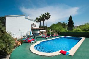 a swimming pool with chaise lounge chairs next to a house at Villa Conxa Bisanyes by Villa Plus in Alcudia