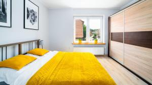 a bedroom with a bed with a yellow blanket at Apartament "Nad Jedlicą" in Kowary