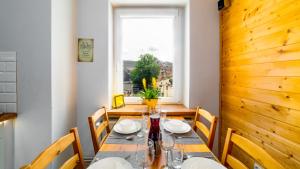 een eetkamer met een tafel en stoelen en een raam bij Apartament "Nad Jedlicą" in Kowary