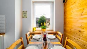a dining room with a table and chairs and a window at Apartament "Nad Jedlicą" in Kowary