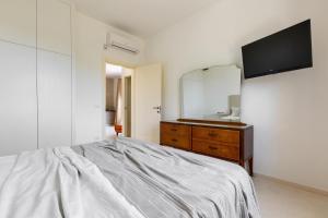 una camera da letto con un letto e un comò con uno specchio di Villa Donna Sofia by Perle di Puglia ad Alezio