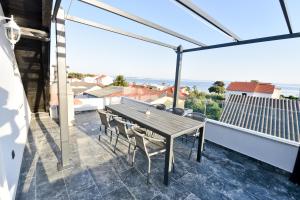 a patio with a wooden table and chairs on a balcony at Apartment Sun in Vir +13 photos