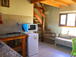 een keuken met een witte koelkast en een magnetron bij Los Neneos Chalten in El Chalten