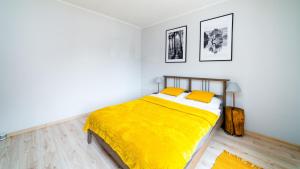 een slaapkamer met een bed met een gele deken bij Apartament "Nad Jedlicą" in Kowary