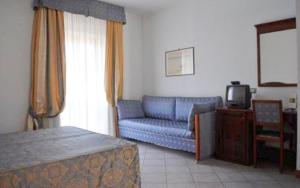 a living room with a blue couch and a tv at Hotel Zodiaco in Bolsena