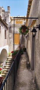 an alleyway with plants and flowers on a building at Le Altezze in Erice