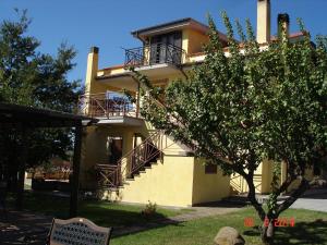 a large yellow house with a balcony and a tree at Agriturismo Casale Di Gricciano in Cerveteri