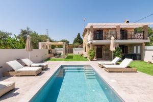 a villa with a swimming pool and a house at Artemis Luxury Villa in Méson Yerakaríon