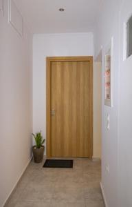 a wooden door in a hallway with a potted plant at Harmony Studios in Nafpaktos