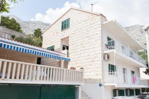 una casa bianca con balcone e un edificio di Mimice View a Mimice