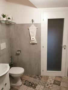 uma casa de banho com um WC branco e um lavatório. em Santino Casa em Galatone