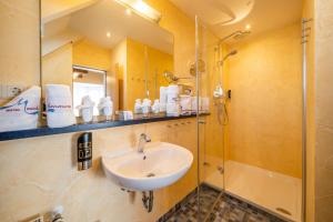 a bathroom with a sink and a shower at Hotel Meschenmoser in Langenargen +44 photos