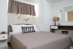 a bedroom with a bed with birds on the wall at Anemone City Center Apartment in Heraklio