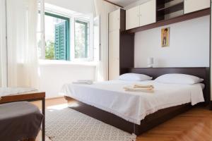 una camera da letto con un letto con lenzuola bianche e una finestra di Mimice View a Mimice