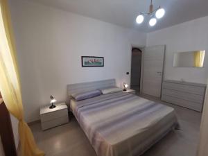 1 dormitorio con 1 cama grande y 2 mesitas de noche en Villetta a piano rialzato a 300 mt dal mare, en Marina di Pescoluse