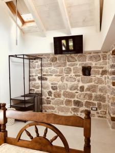 a room with a stone wall and a wooden chair at Guesthouse Giraffe in Tivat +22 photos