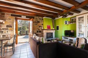 un soggiorno con divani e camino di Casa Rural Ángela 1 a Villanueva de la Peña