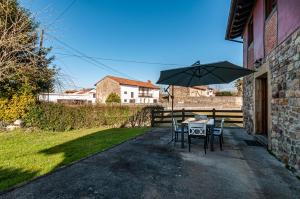 un tavolo con sedie e un ombrellone in un patio di Casa Rural Ángela 1 a Villanueva de la Peña