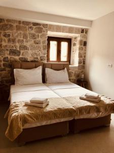 a bedroom with a bed with two towels on it at Guesthouse Giraffe in Tivat