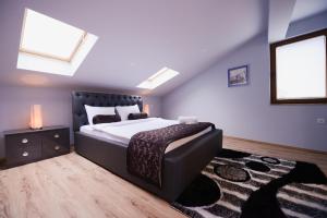 una camera con un grande letto con testiera nera di Millenium Travel Apartments a Bitola