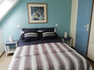 sypialnia z dużym łóżkiem z niebieską ścianą w obiekcie FACE A LA MER w mieście Fouesnant