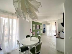 - une salle à manger blanche avec une table et des chaises blanches dans l'établissement LovingStresa 2 brand new apartment, à Stresa