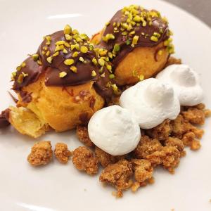 een witte plaat met twee donuts met slagroom en pinda's bij Hotel Galassia in Rimini