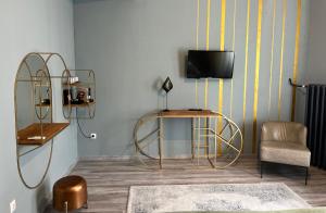 a living room with a tv and a table and a chair at W Urban Suites Budapest in Budapest