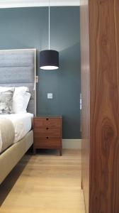 a bedroom with a bed and a dresser and a lamp at Boutique Barclay House London townhouse - West London, Kensington, Chelsea, Fulham in London