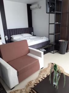 een woonkamer met een bank en een bed bij Hotel Aglon in Vlorë