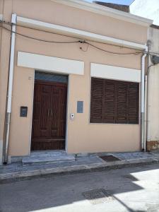 ein Gebäude mit zwei braunen Türen und einer Straße in der Unterkunft Casa Don Mario in Ispica