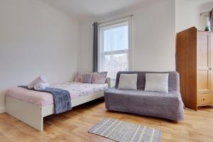 a bedroom with a bed and a couch and a chair at Heron Court Holiday Apartments in Bournemouth