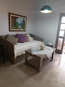a living room with a couch and a table at Buganvilla Sea View apts in Agia Pelagia